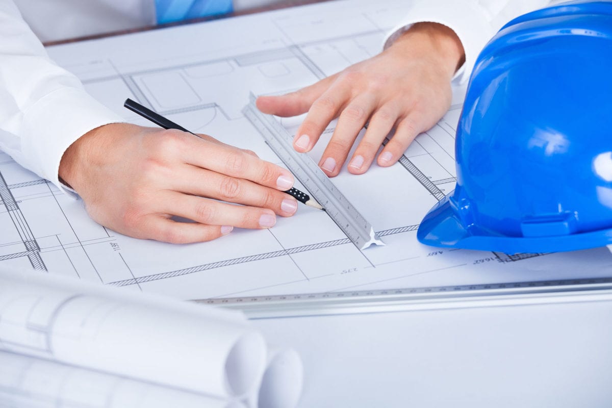 21254350 - close-up of male architect working on blueprint at desk